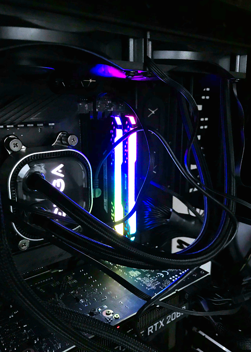 Close up of motherboard with AIO cooler connected to CPU and RAM sticks lit up.