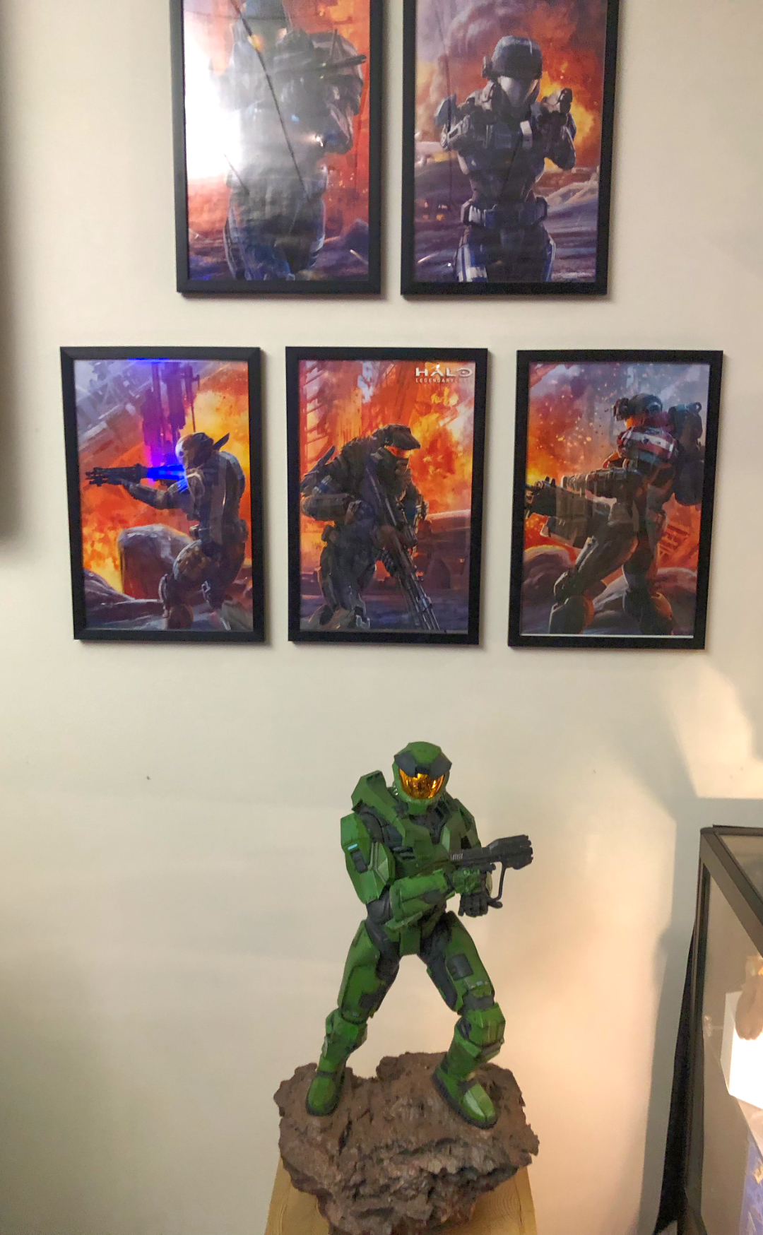 Master Chief along some Halo Reach posters on the wall