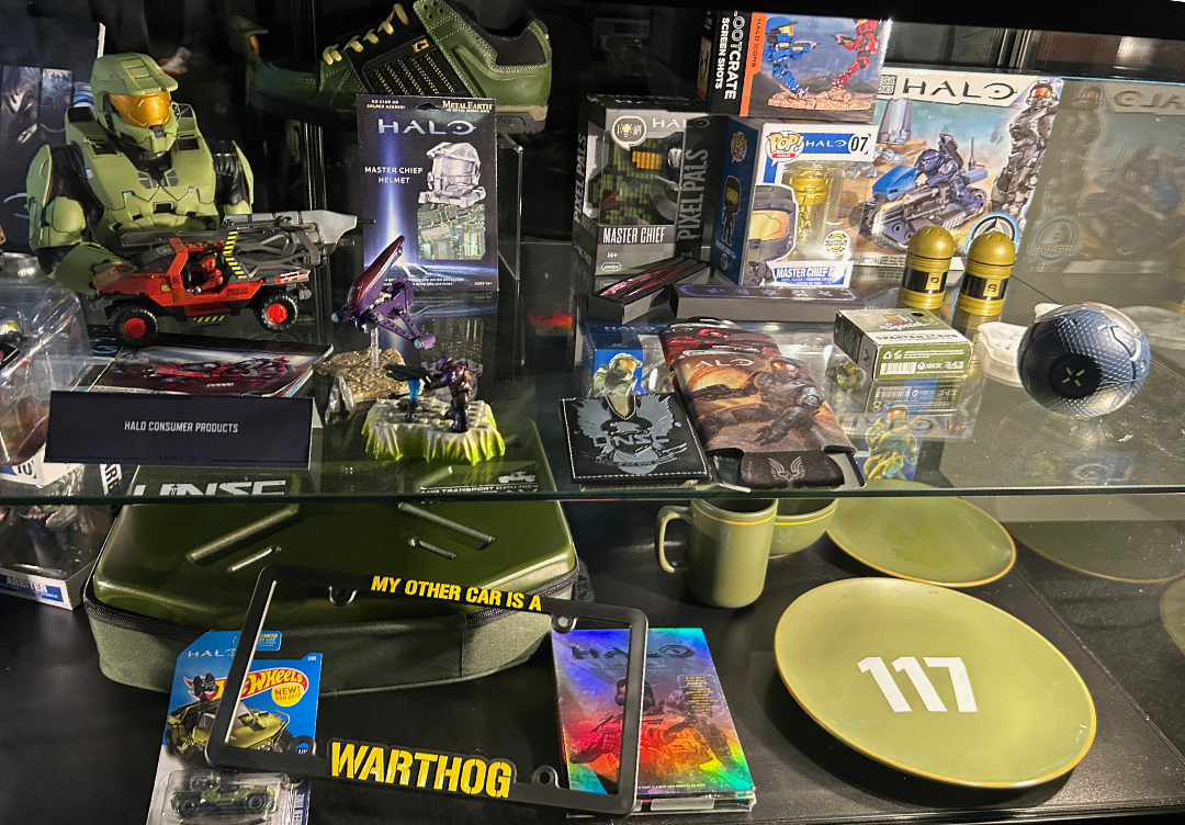 Halo plates on a museum shelf, along with smaller Halo merch