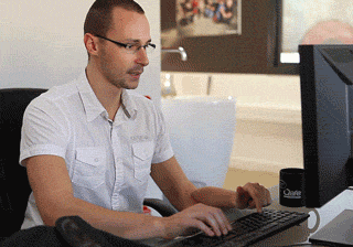 A GIF of a person typing on laptop and drinking coffee